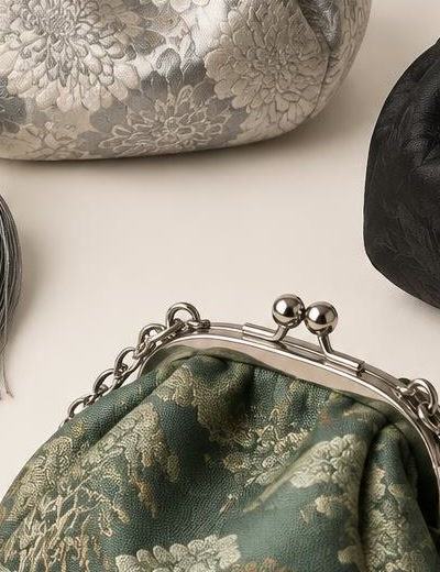 Close view of a blue-grey brocade pouch with a pale cloud pattern and a knotted cord